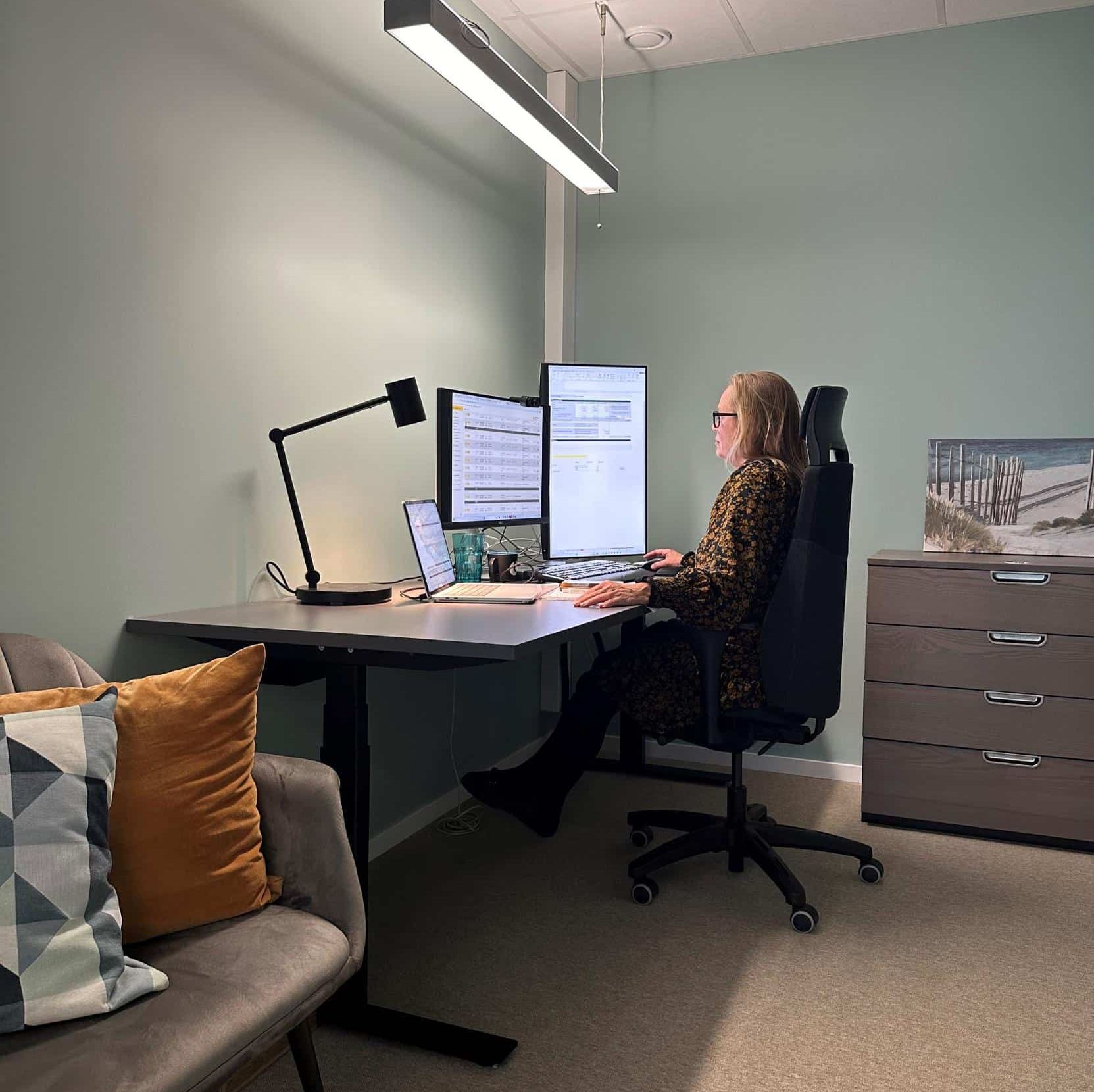 Kvinne sitter foran en pc