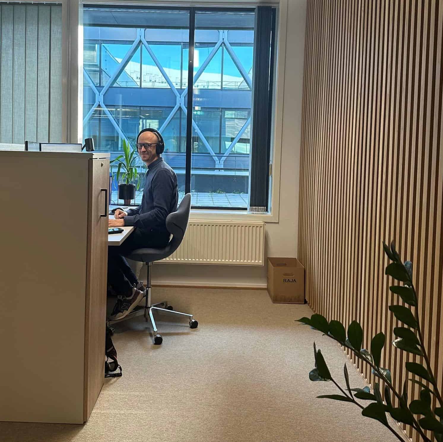 Mann sittende i en stol i et kontor